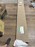 Long cardboard box containing guide rail, labeled ‘TrackSaw Track,’ with printed sticker showing rail