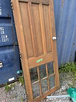 Full view of wooden door showing entire height, glass panels at the bottom, and white door knob.