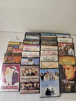 Photo of 23 DVDs stacked showing a variety of movie titles and themes