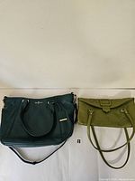 Photo showing both purses side by side on a white background, dark green leather Cole Haan tote on the left and light green embossed handbag on the right.