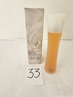 Perfume bottle and original box showing front with white gardenia flower image and text.