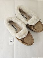 Top angle view showing overall look, wool lining, and suede body of slippers.