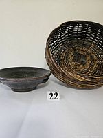 Pottery colander and woven basket side by side showing size and shape