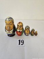 Five Russian political leader nesting dolls arranged in size order on a plain background with lot number card visible.