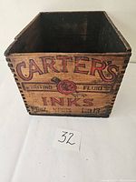 Front view of wooden box showing Carters Ink logo and text on one side.
