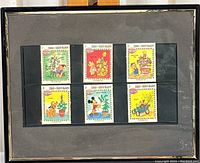 Six Disney-themed stamps from Turks and Caicos Islands Christmas 1983 arranged on black backing.