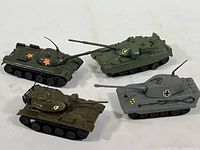Four miniature military tanks in different color schemes displayed together on white background.