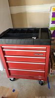 Front view of the red Craftsman tool chest with four drawers and black plastic top organizer.