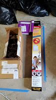 Photo showing boxed and packaged items including dryer vent cleaning system, steam dryer hose kit, and motor boxes.