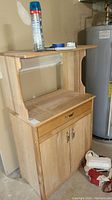 Front view of wooden microwave cart with open shelf, drawer, and closed cabinet doors showing overall design and condition.