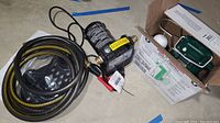 Photo of Zoeller sub pump with coiled hose and pump stand, black pump casing with label visible