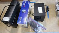 Photo showing all items: CyberPower UPS, Sony DVD/CD drive box, Logitech speaker box, additional speakers, cables in plastic bag.