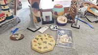 Full lot showing figurines, coasters, vases, wall hangings, and trinket jar on carpet floor