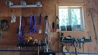 Wide view of pegboard with assorted tools including pliers, screwdrivers, drill, speakers, radio, clamps, and cords hanging.