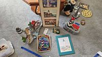 Wide view of all lighthouse figurines, stained glass, and framed art on carpeted floor