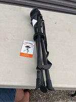 Photo showing closed tripod stool with tag indicating Eclipse brand and model, in carrying case with shoulder strap.