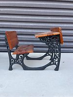 Side view of the mini desk showing cast iron frame and wood seat and backrest