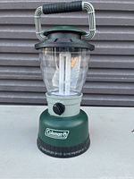 Front view of the green Coleman lantern showing overall condition and handle.