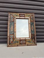 Front view of the framed rectangular mirror with intricate colorful decorative border.