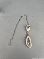 Necklace with sterling silver chain and antler pendant with inset carving of a figure