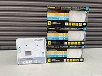 Photo shows three Luminus DEL 10 in 1/4 LED panel lights stacked horizontally and one Standard low profile LED flood light box on left side.