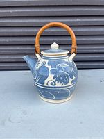 Front view of the teapot showing bird motif and bamboo handle