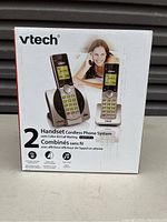 Closed box showing VTech 2 handset cordless phone system with model CS6919-2, images of phones and a woman on phone.