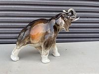 Side profile view of the glazed porcelain elephant figurine showing coloration and texture