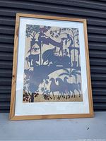 Framed colorful silhouette-style print depicting animals, horses, people, and foliage in a naturalistic scene.