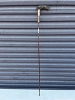 Full view of the Victorian parasol cane showing the entire length and handle shape.