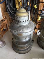 Front view of lantern showing overall shape, brass top, metal housing and ribbed glass globe