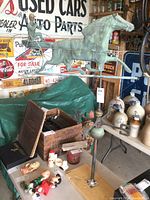 Overall view of the complete copper horse and cart weathervane mounted on iron rod among workshop items