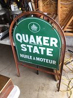 Front view of green Quaker State tombstone sign in original arched frame