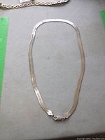 Full view of the chain laid on a flat surface showing its length and clasp.