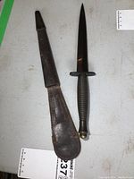 Dagger and sheath laid flat, top-down view