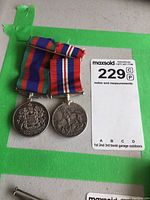 Pair of two Canadian WW2 sterling silver medals lying flat on a surface with their ribbons attached, showing front sides.