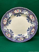 Front view of antique 19th century Spode faience plate showing multicolor floral and leaf motifs with scalloped edge.