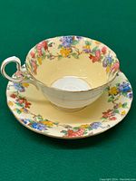 Top view showing floral pattern inside and on rim of teacup with matching saucer underneath