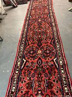 Full-length view of the runner showing red field and floral pattern