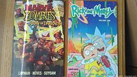 Photo showing the front covers of both graphic novels: Marvel Zombies vs Army of Darkness and Rick and Morty Volume 1.