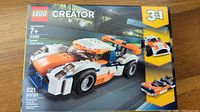 Front of the sealed LEGO Creator 31089 box showing the main race car model in orange, white, and blue with 221 pieces indicated.