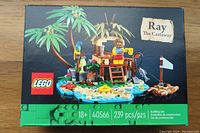 Front view of the sealed Lego set box showing the island build with hut, palm trees, raft, and minifigure. Box indicates set number 40566 and age 18+