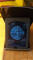 Clear acrylic plaque featuring blue etched Lego Death Star design in black foam holder and cardboard box