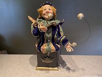 Full front view of the Jacqueline Kent Royal Jester "Justinian" collectible figurine on black base with three juggling balls.
