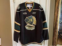 Front view of black London Knights jersey hanging on a hanger
