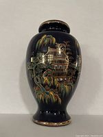 Front view of cobalt blue Japanese vase featuring hand-painted enamel pagoda scene with gilding accents on rim and base.