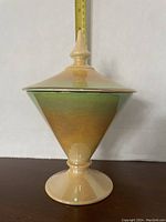 Full view of Royal Winton candydish showing conical shape, pedestal base, pointed finial lid, and gradient tangerine to lime green opalescent glaze. Approximately 8 inches tall.