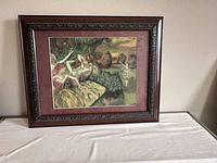 Framed lithograph art print depicting ballet dancers by Catalina, placed against a wall on a table.