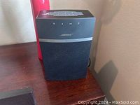 Bose wireless satellite speaker with top control buttons and black mesh front