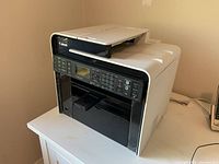 Front and side view showing control panel, buttons, display, and Canon branding.